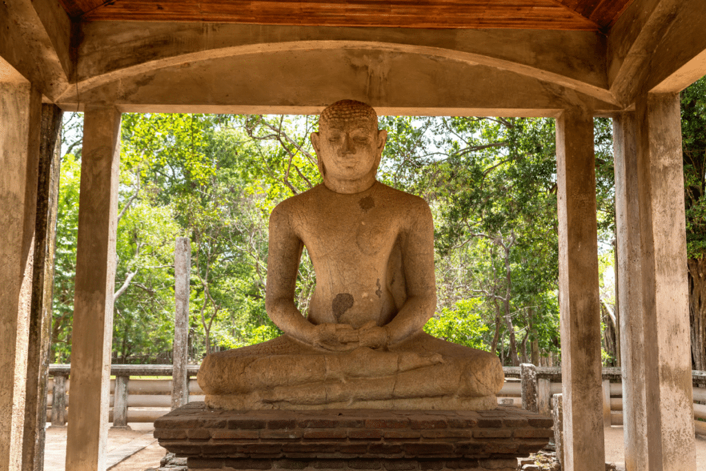 A statue of a buddha sitting under a gazebo.