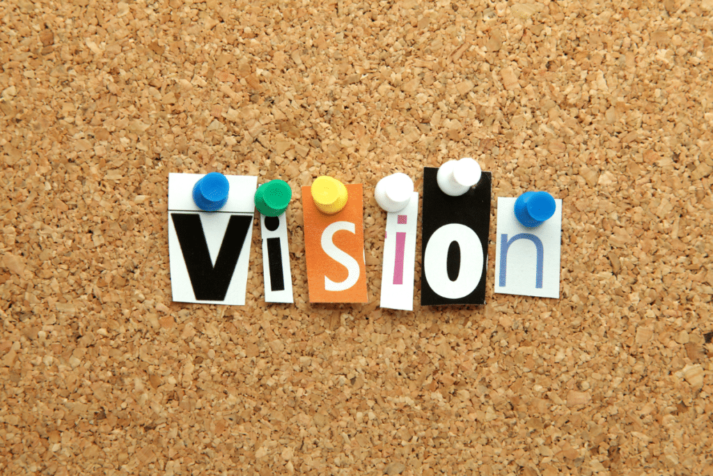 The word vision is written on a cork board.