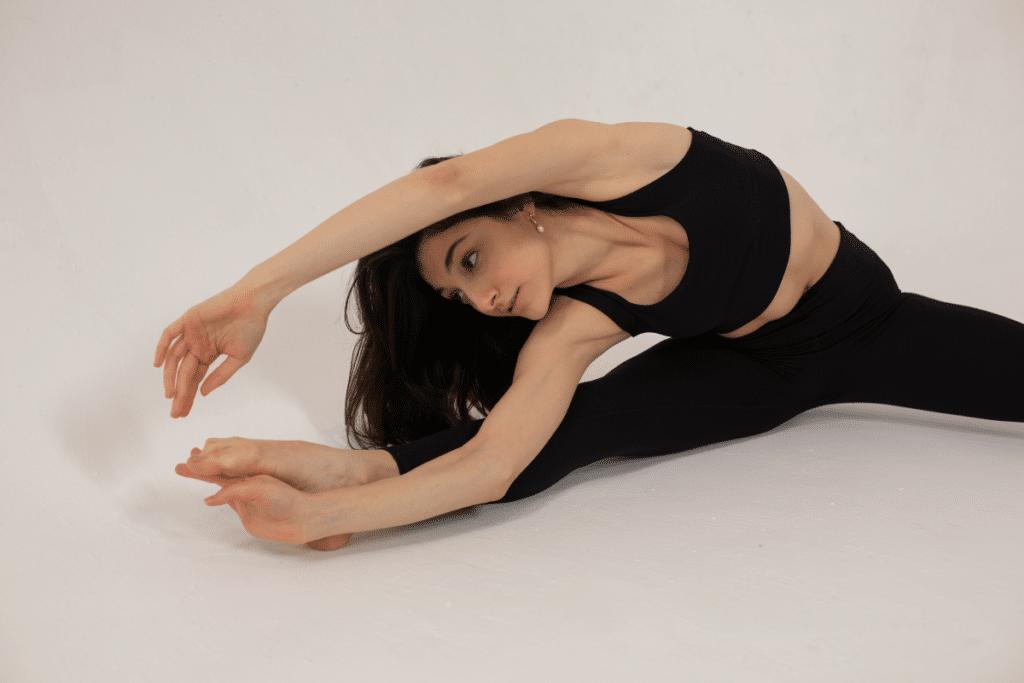 A woman doing a yoga pose on a white background.