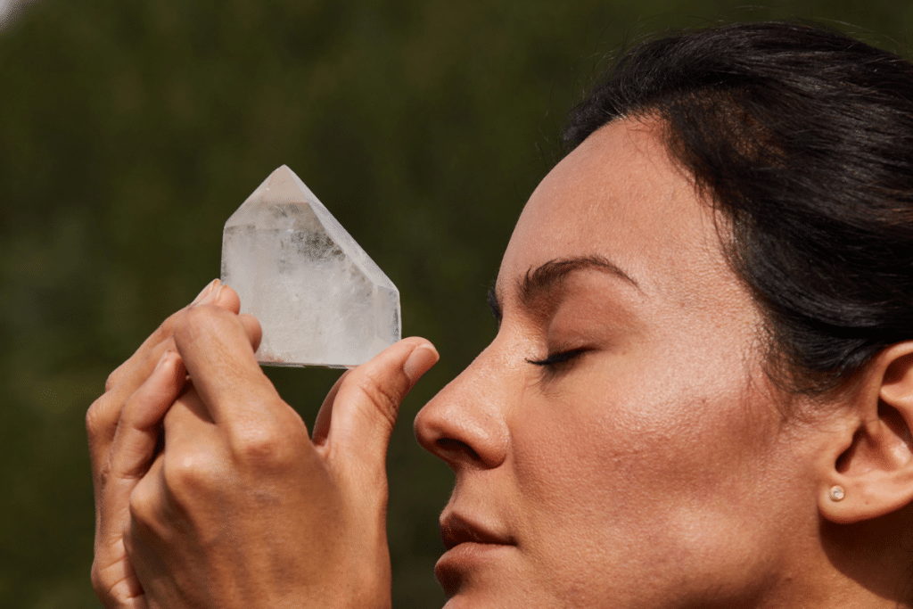 A woman is holding a piece of crystal in her hand.