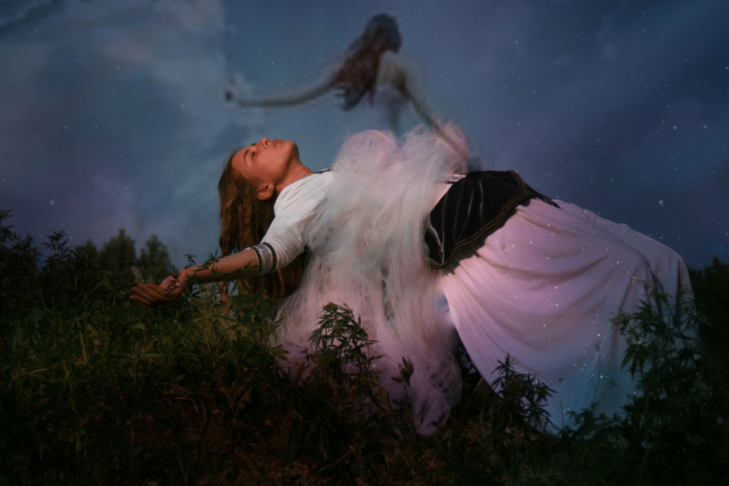A woman in a white dress in a field with a star in the sky.