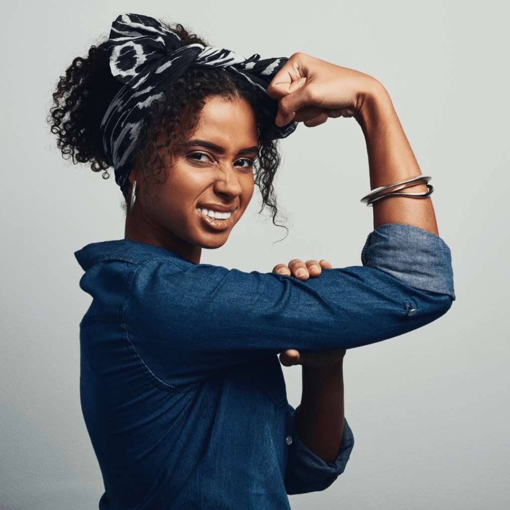 Young african american woman flexing her muscles.
