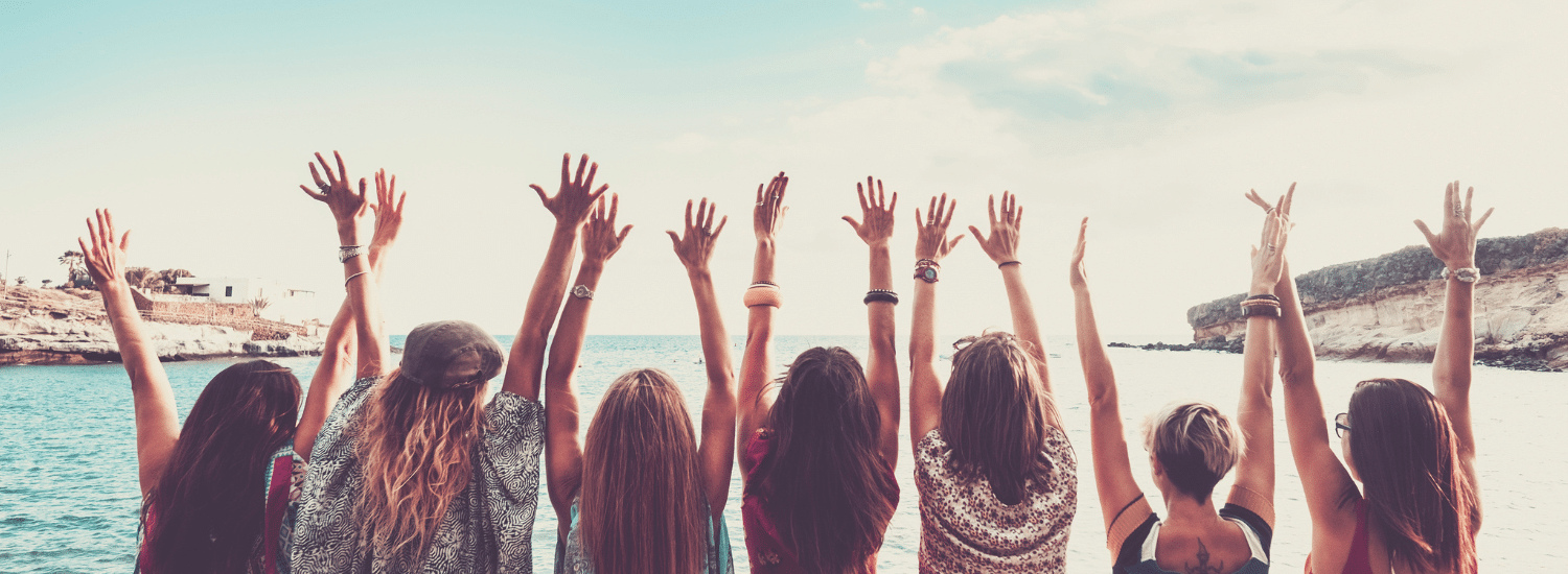 A group of girls with their hands raised in the air.