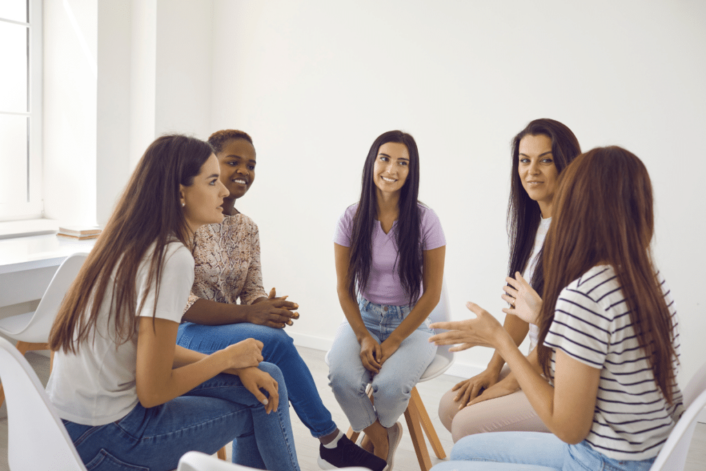 A group of women sitting in a circle talking to each other.