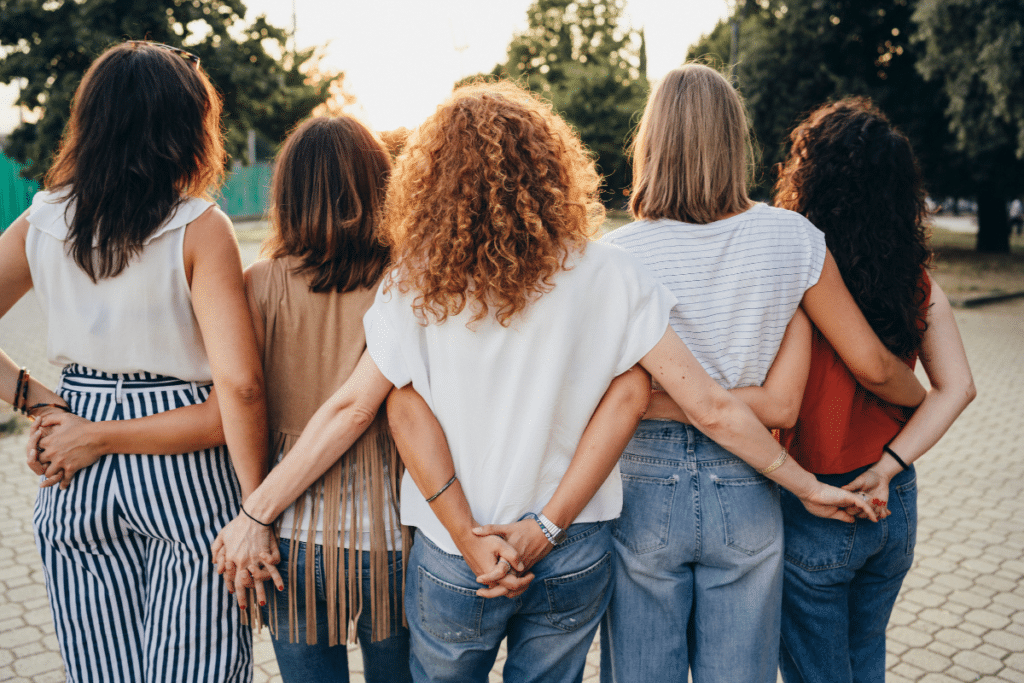 A group of women holding hands in a park.