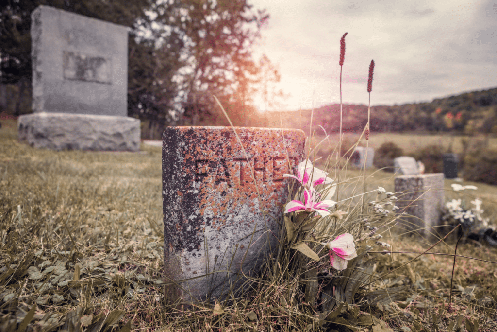 A graveyard with flowers and a gravestone.