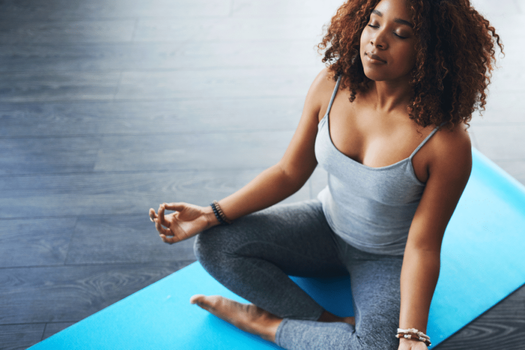 A woman meditating on a yoga mat.