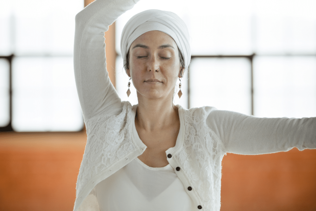 A woman in a white turban doing yoga.